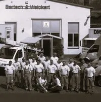 Historisches Gruppenfoto vor einem Gebäude mit Bartsch-&-Weickert-Schriftzug.